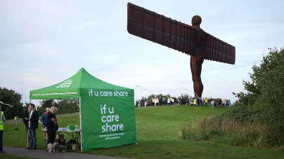 An If U Care Share tent in front of the Angel of the North